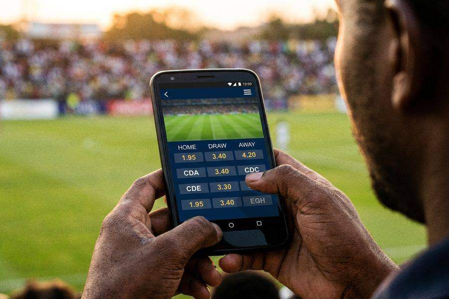 A phone showing football odds at a stadium